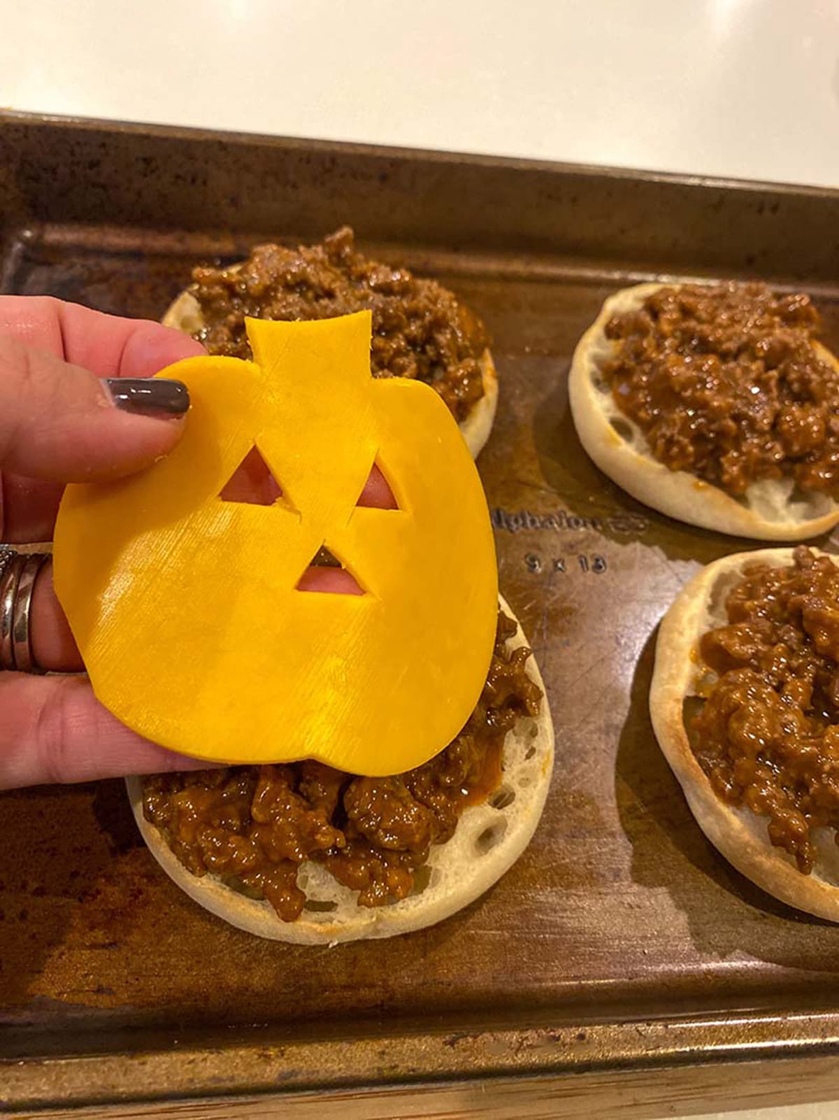 place pumpkin shaped cheese on top pf meat mixture and muffins