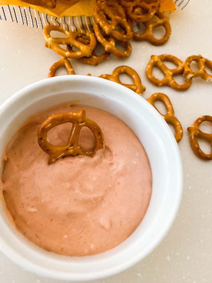 pretzel dip in bowl with a pretzel