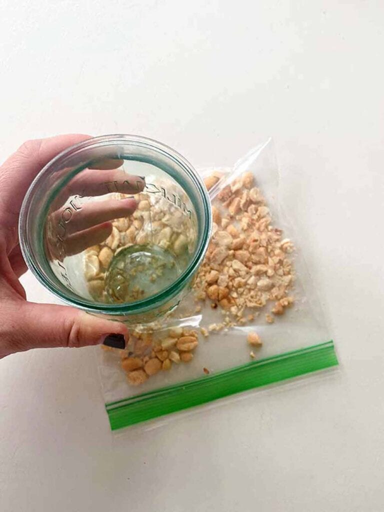 use bottom of a drinking glass to crush peanuts in a baggie