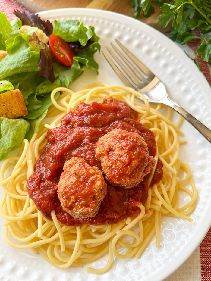 ground turkey meatballs and pasta with salad on white plate