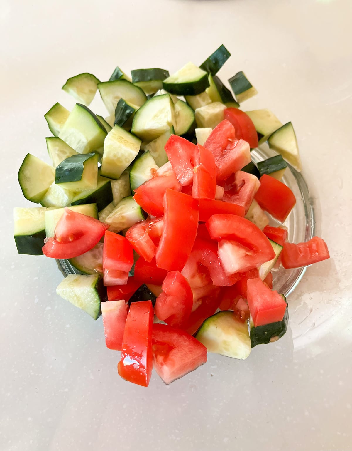 combine tomatoes and cucumbers in a bowl