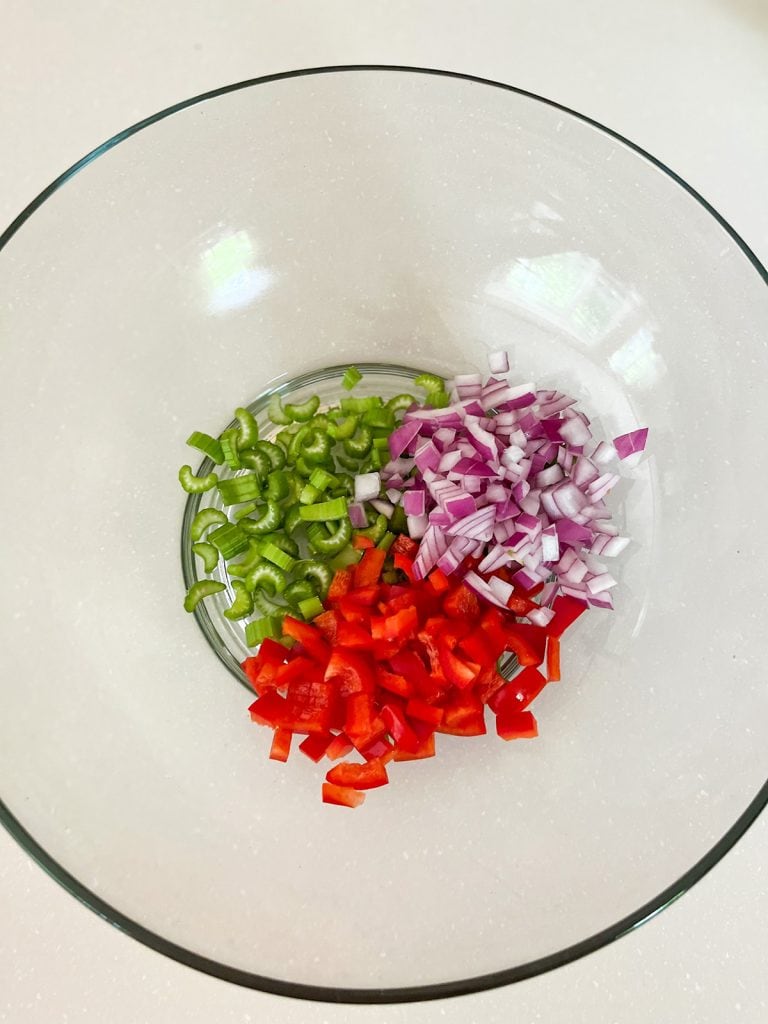 diced onion, red peppers and celery in a bowl