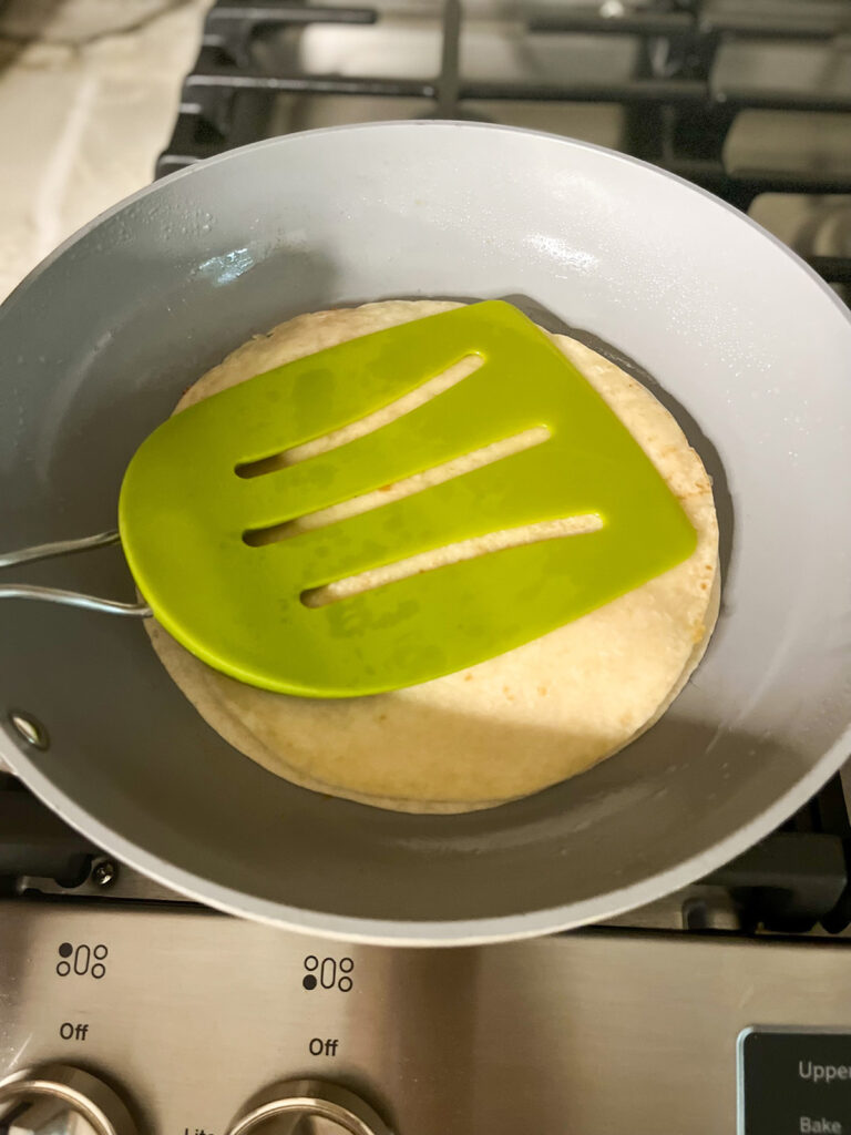 use large spatula to flip tortilla