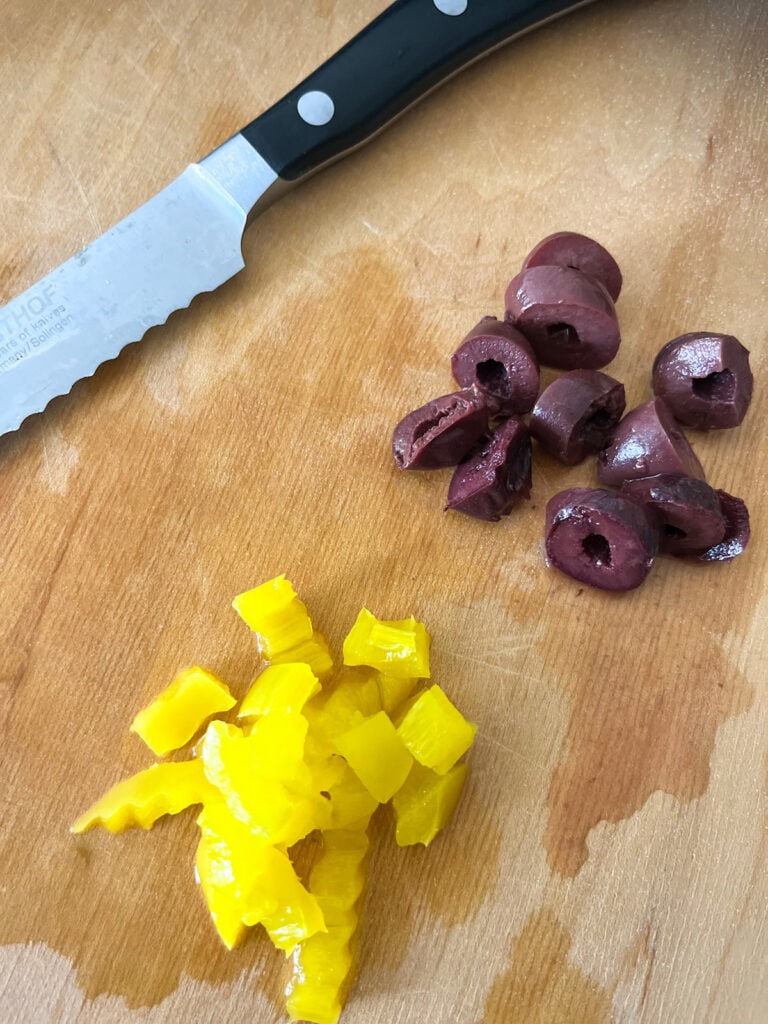 chopping black olives and banana peppers