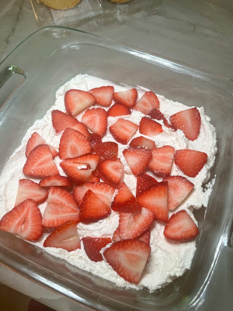 strawberries on top of whipped cream for sugar cookie strawberry shortcake