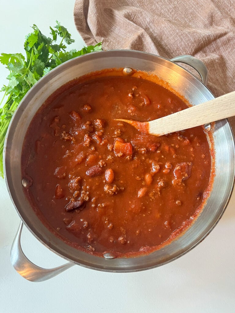 Chili with Tomato Juice in a large put with cilantro