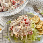 BLT Chicken Salad in a large bowl, and a scoop on a plate with shredded lettuce and crackers with a fork