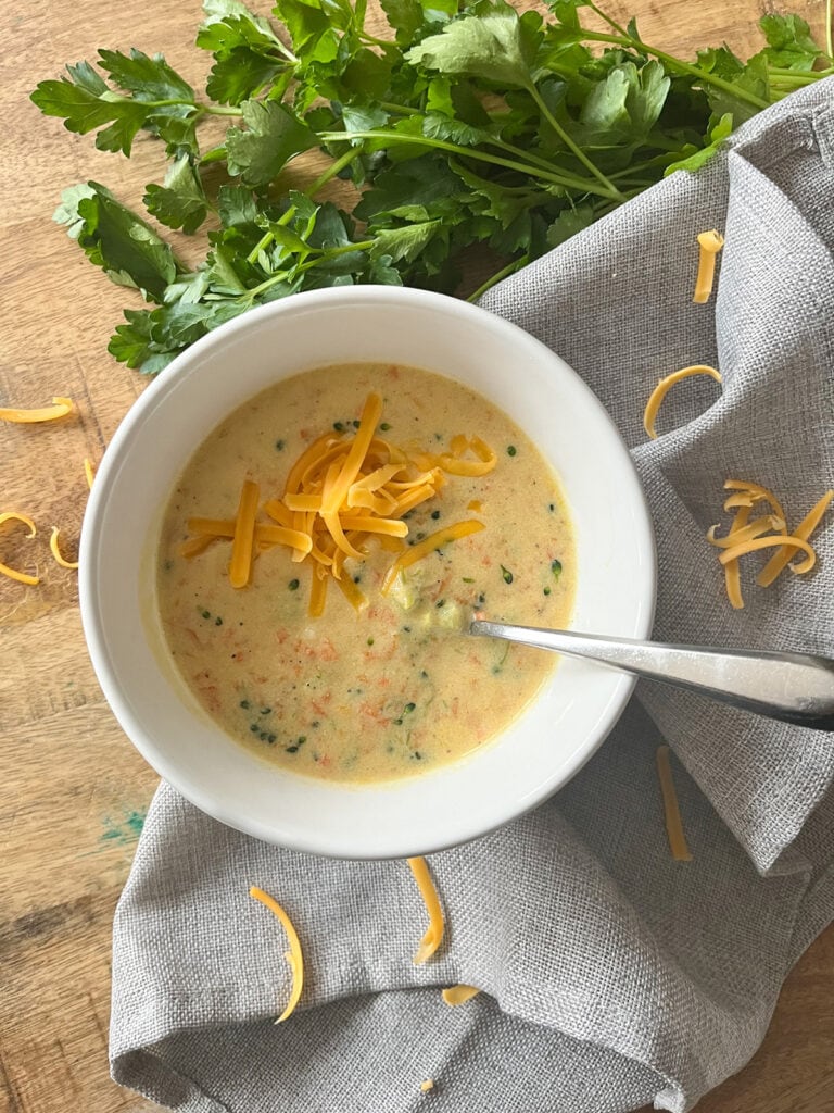 Broccoli Cheese Soup in a bowl with a spoon and garnish