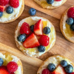 (Red, White & Blue) Mini Sugar Cookie Fruit Pizzas on a wood tray