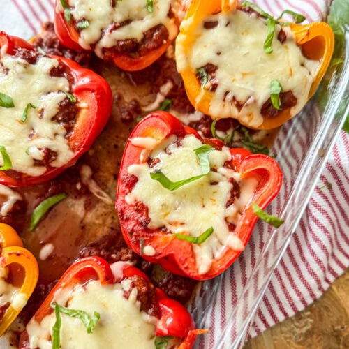 close up of red and yellow Italian Stuffed Peppers in a baking dish