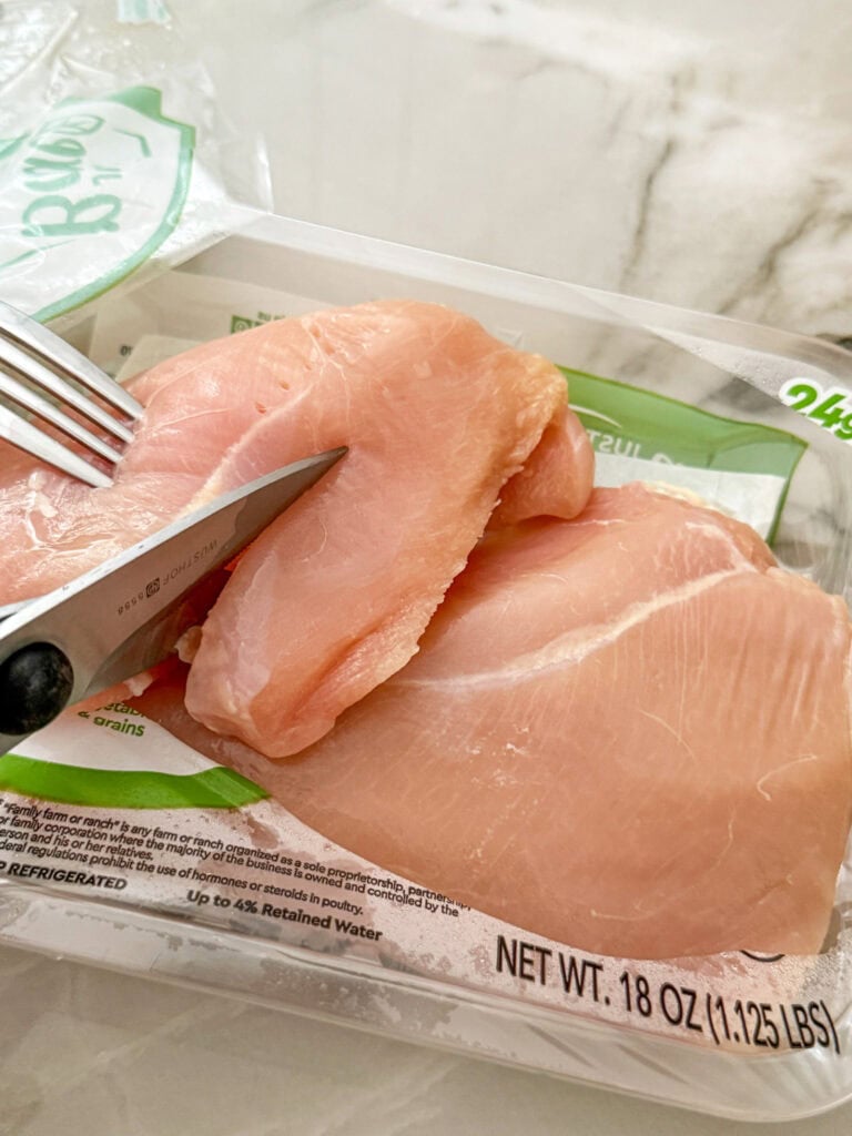 cutting chicken breasts into strips with kitchen shears