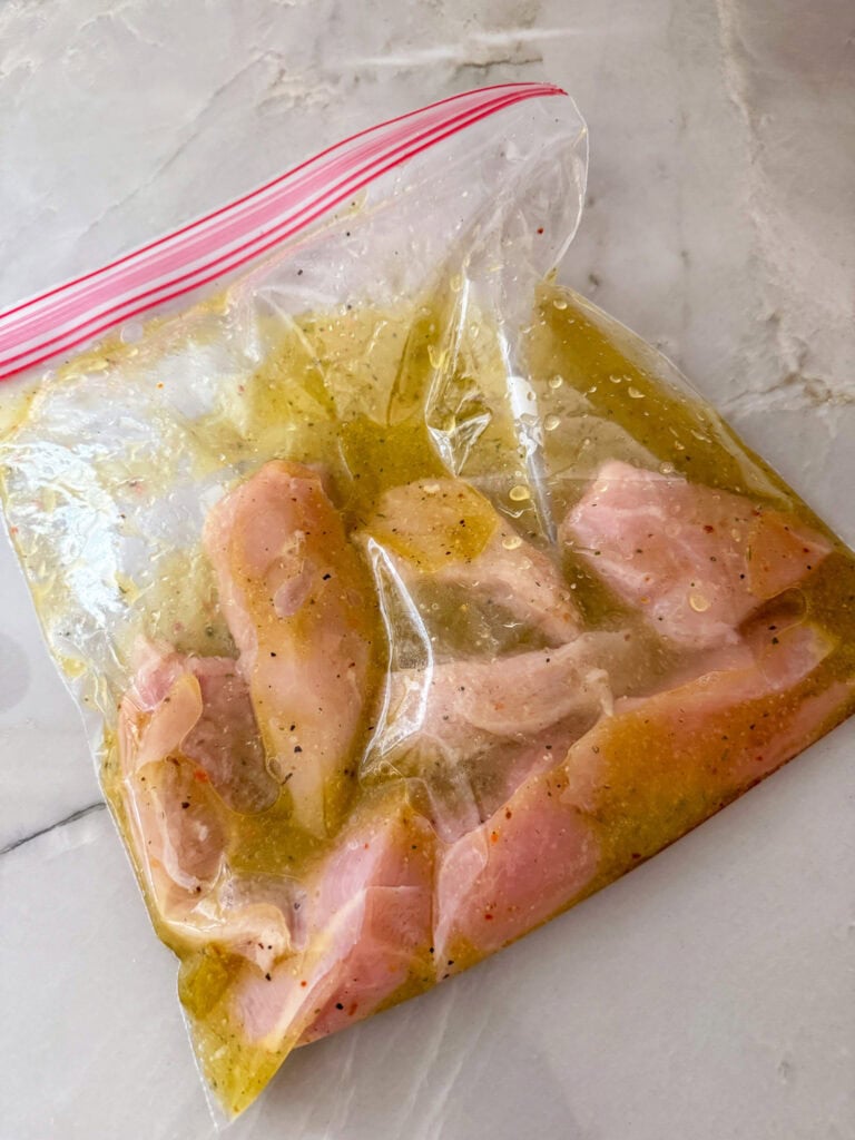 sealed ziplock baggie of chicken and marinade on counter