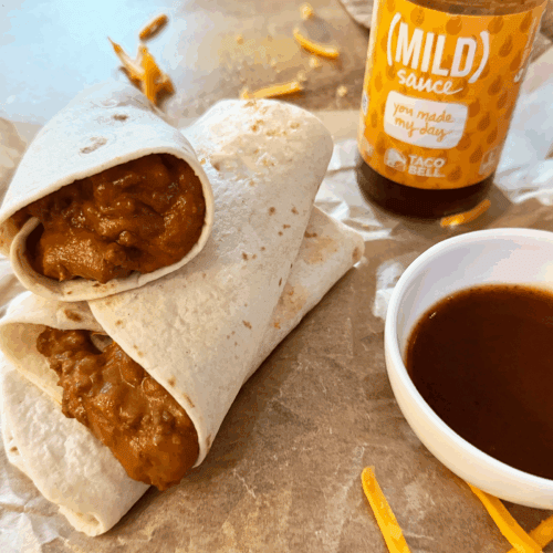 a stack of Copy Cat Taco Bell Chili Cheese Burritos with mild sauce in background