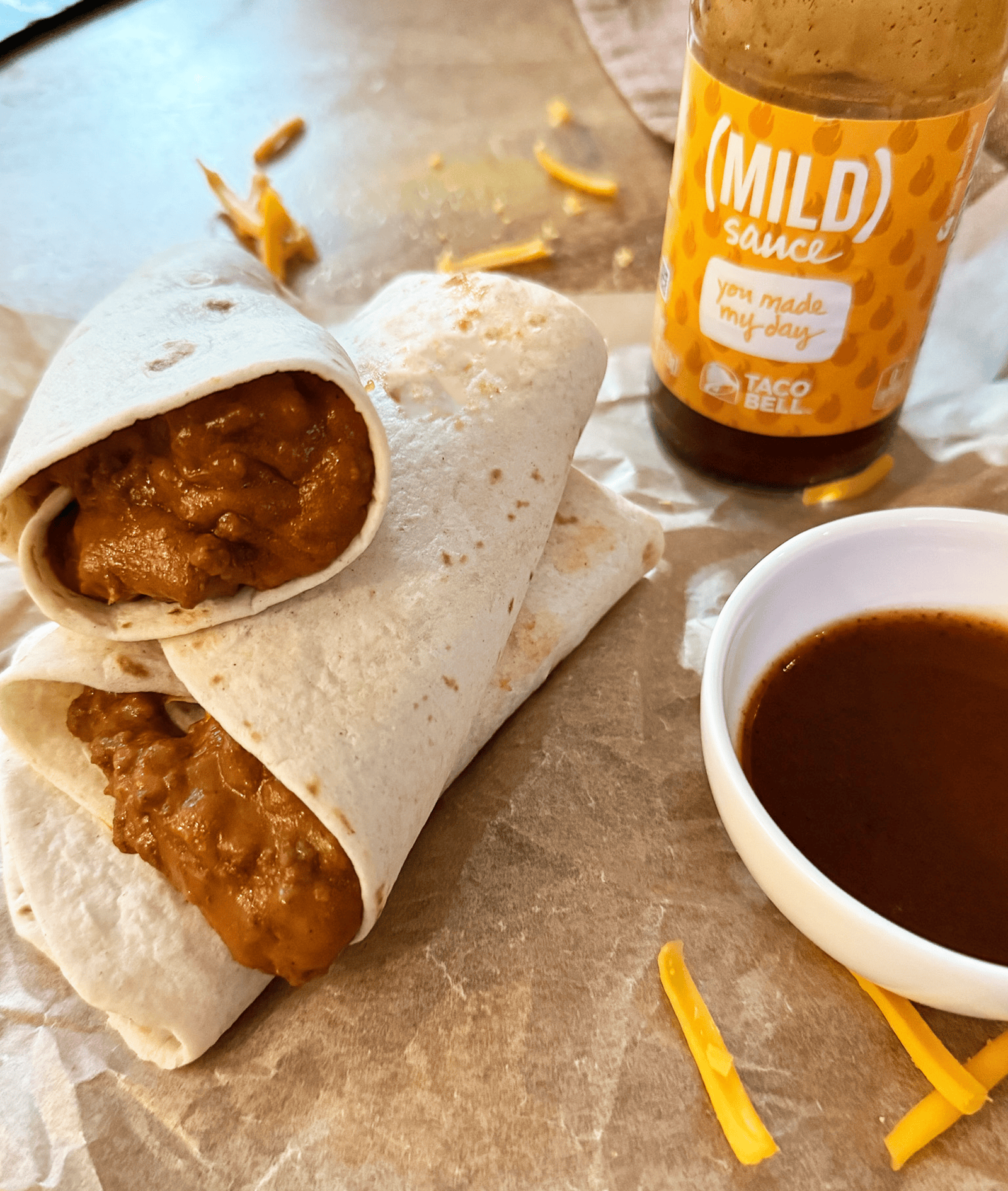 a stack of Copy Cat Taco Bell Chili Cheese Burritos with mild sauce in background