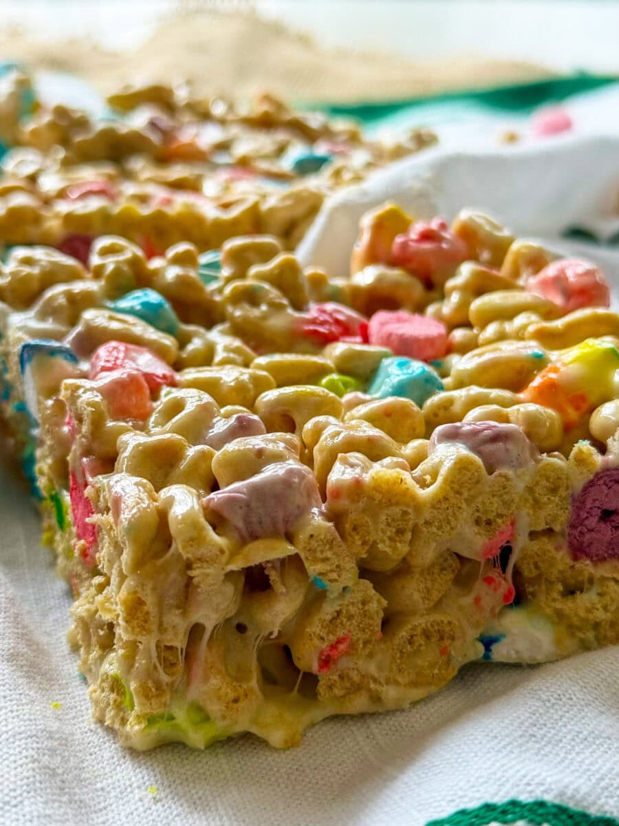 Lucky Charms Cereal Bars cut into squares on a white and green napkin ready to serve at a party