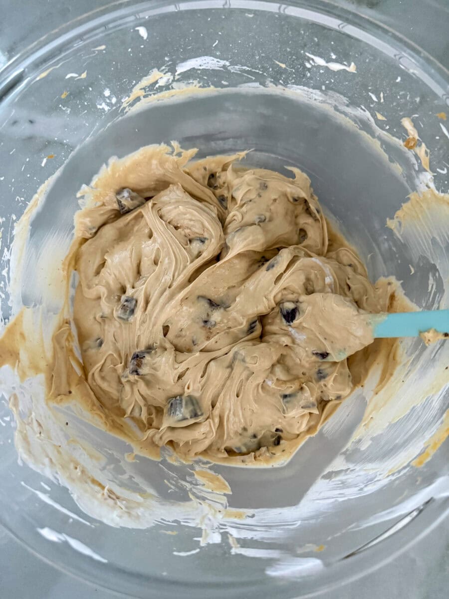 Reese's Peanut Butter Cup Dip all mixed together in a glass mixing bowl with a blue spatula