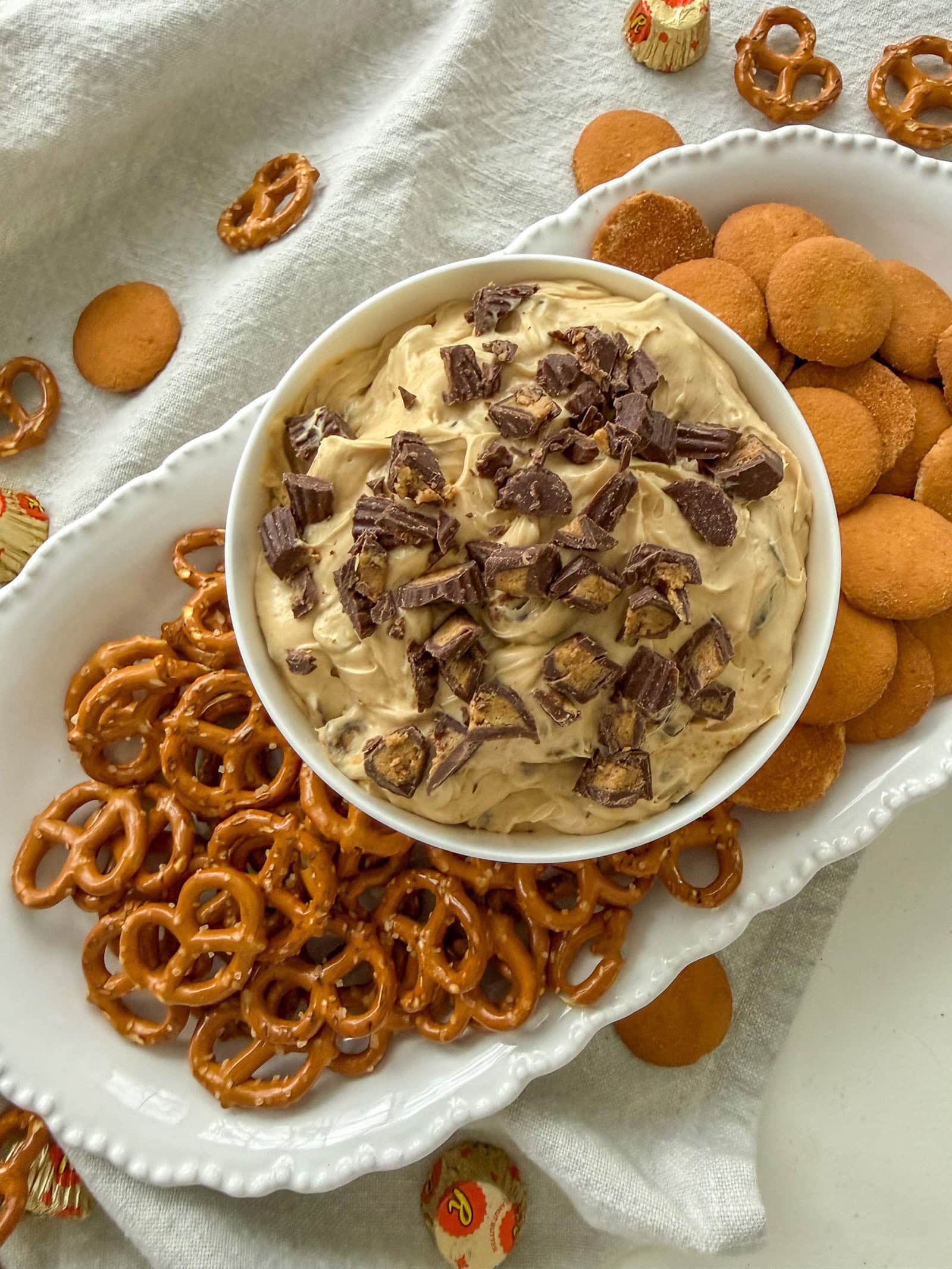 Reese's Peanut Butter Cup Dip on a white platter with Nilla Wafers and pretzels for dipping