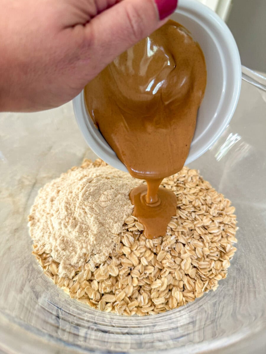 pouring warm peanut butter into oat mixture