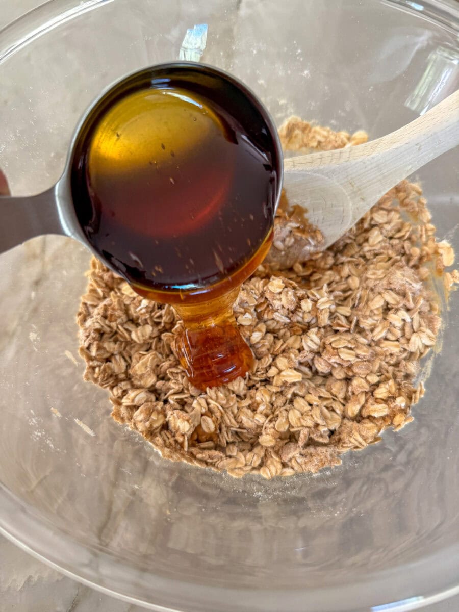 pouring honey into oat mixture in large bowl